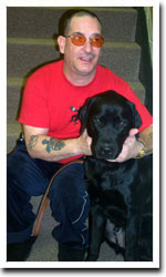 Man with tattoos with black lab