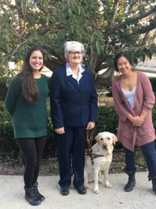 Abby and her fellow raiser smile for a photo with yellow lab guide dog Fanta and her new handler after graduation.