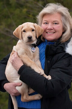 Lorraine poses with one of the puppies she has helped raise