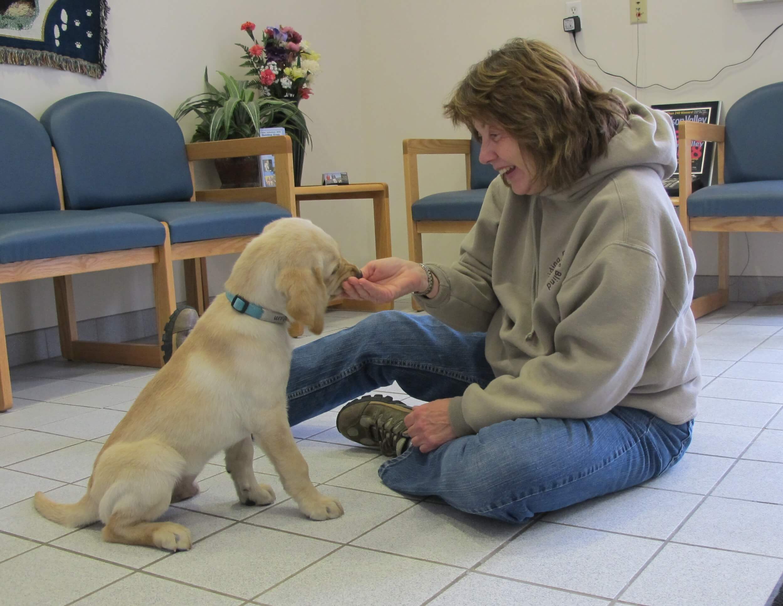 STEP instructor ML Hansen works with a young pup at the Guiding Eyes Canine Development Center