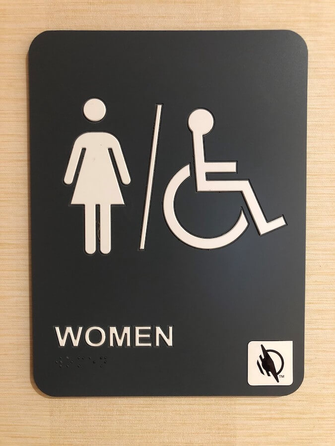 woman's restroom signage with a WayTag NFC tag 