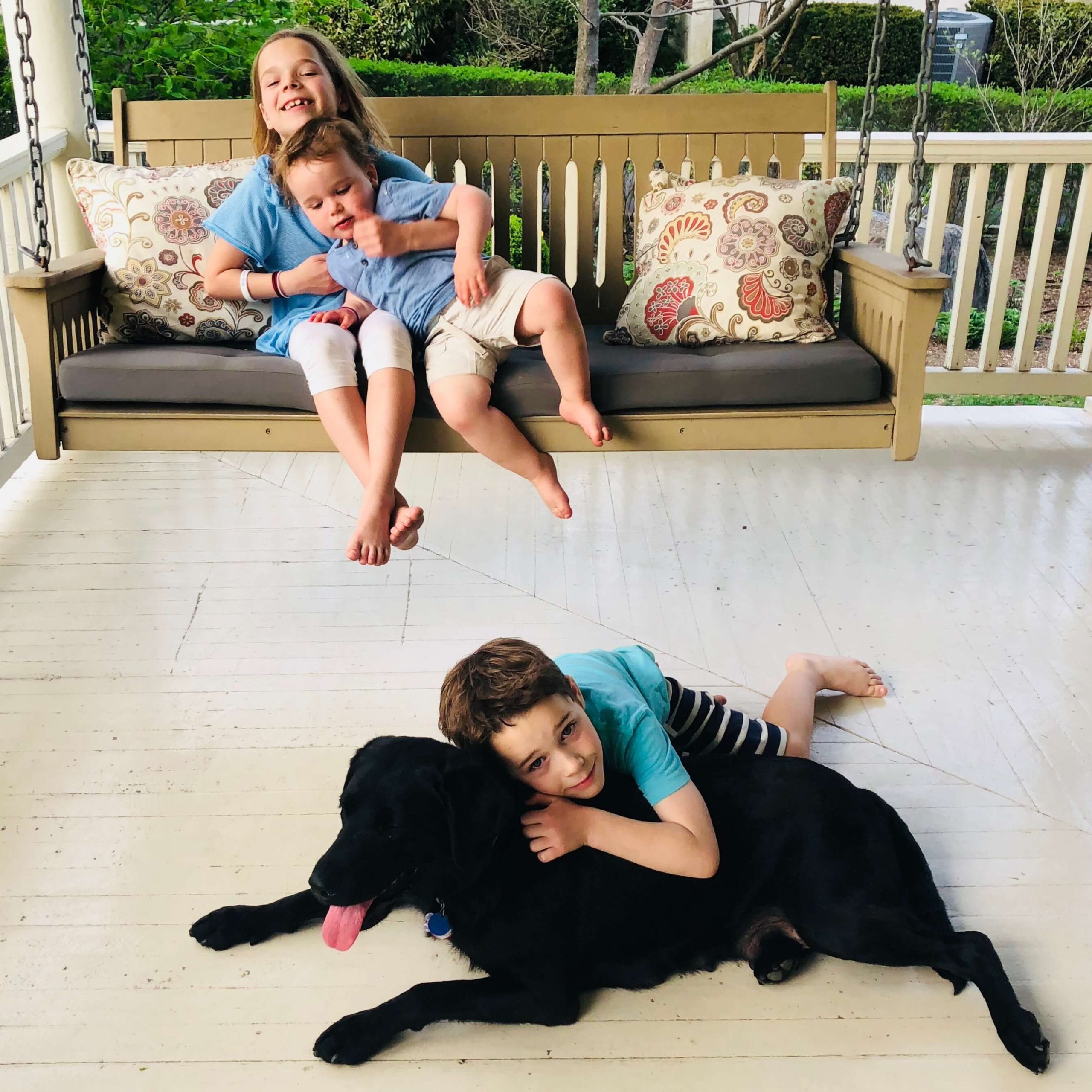 Guiding Eyes brood Haven relaxes on a porch with the Mingey children