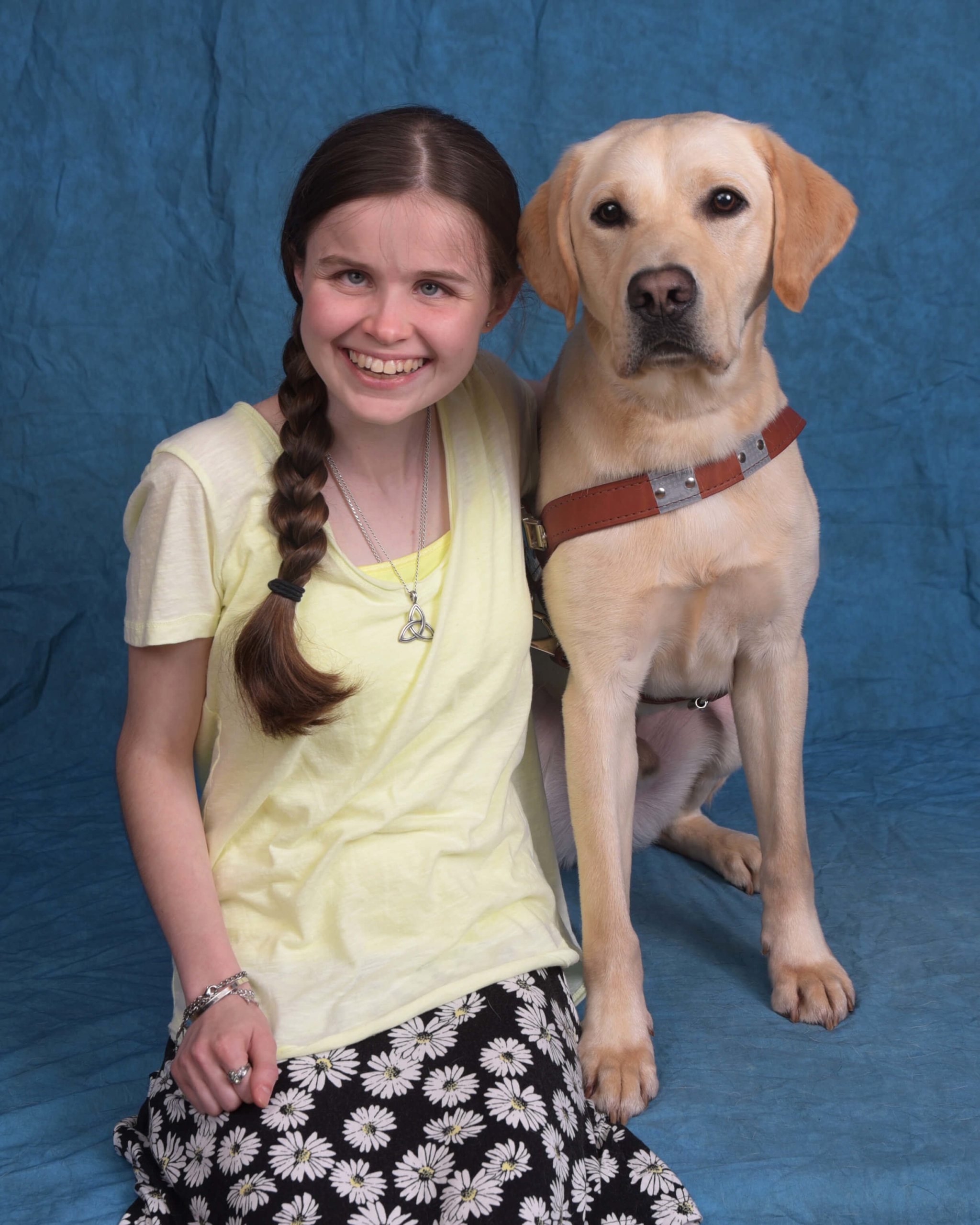 Caitlyn and Aladdin, a yellow lab guide dog in harness.