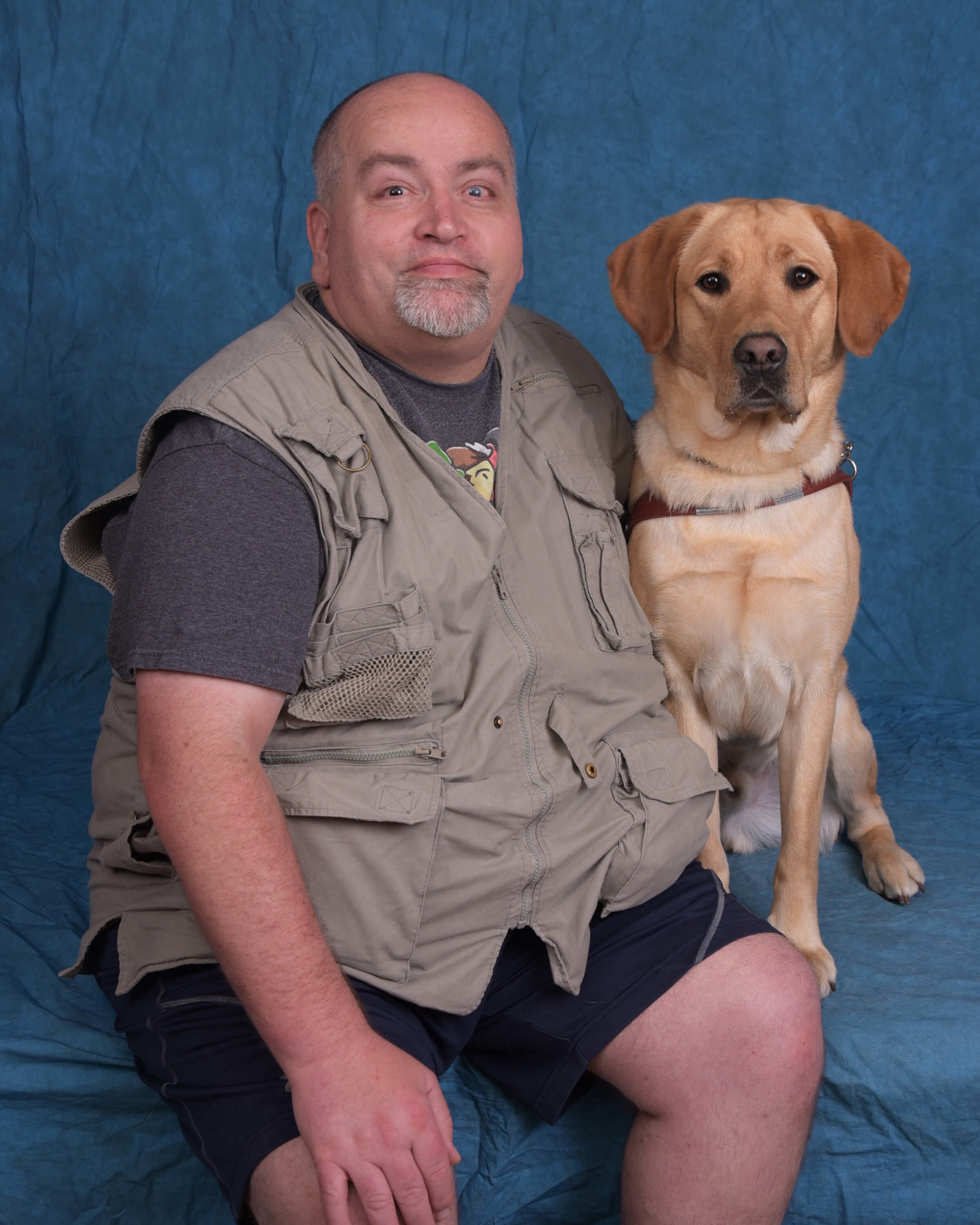 Chris and Jones, a yellow lab guide dog in harness.