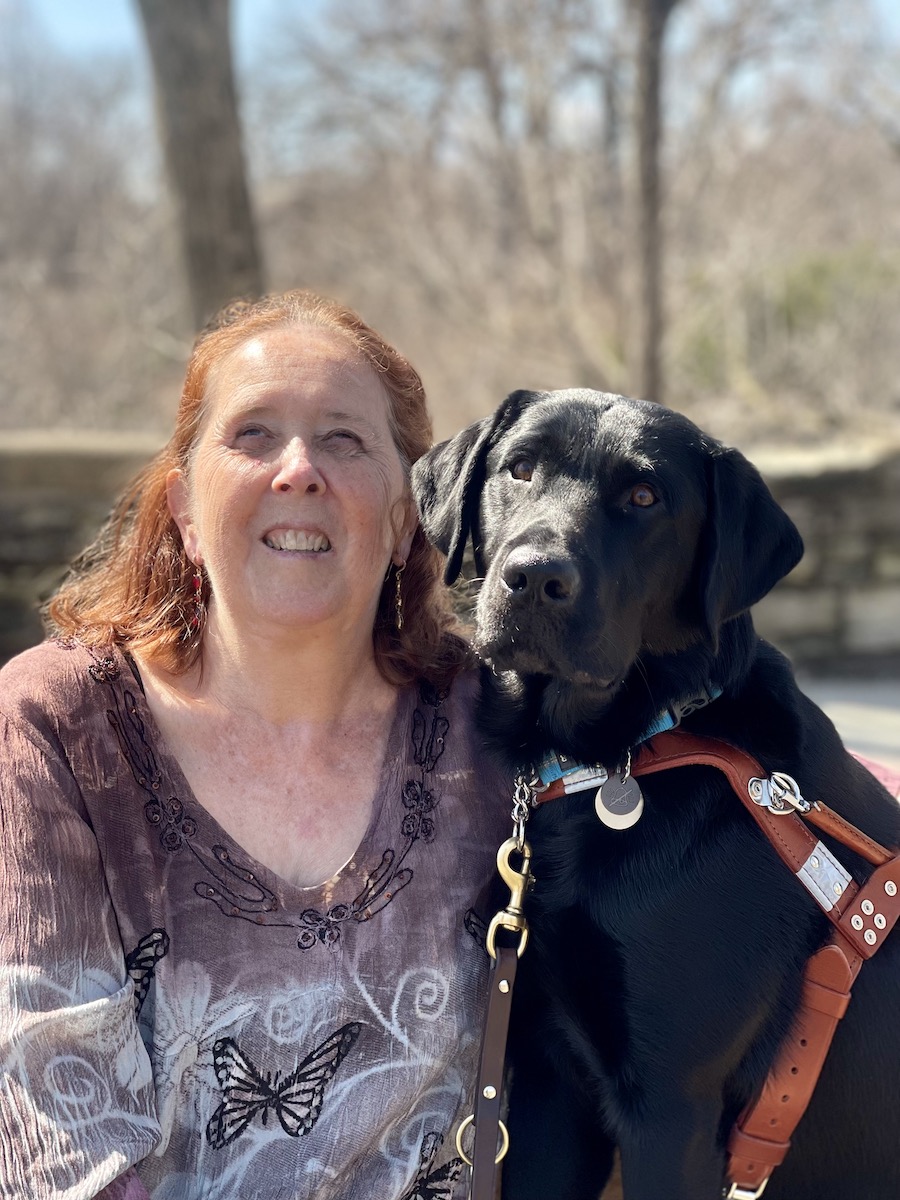 Graduate Colleen and black Lab guide Drake