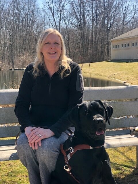 Deborah and her new guide dog Ames take a break in the sunshine