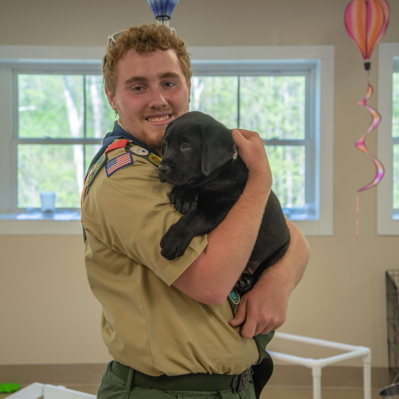 Eagle Scout Ray Schmidt poses for a picture holding Guiding Eyes puppy North