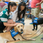 Children pet a Guiding Eyes guide dog during Lions Day event