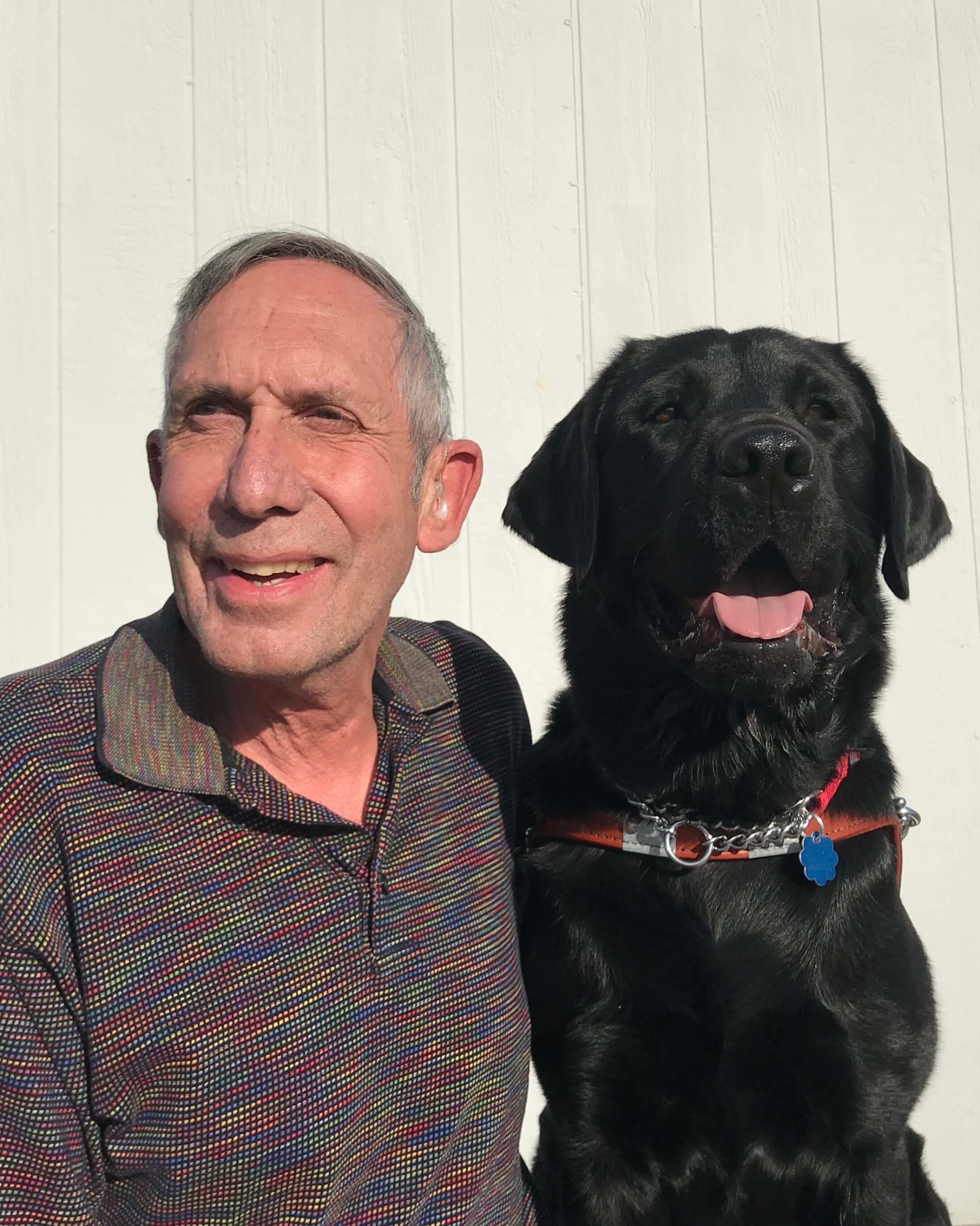 Graduate Gary and guide dog Enzo smile for a photo together