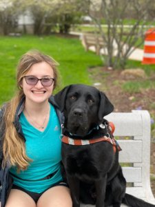 New grad Hailey is all smiles on campus with guide dog Cleo