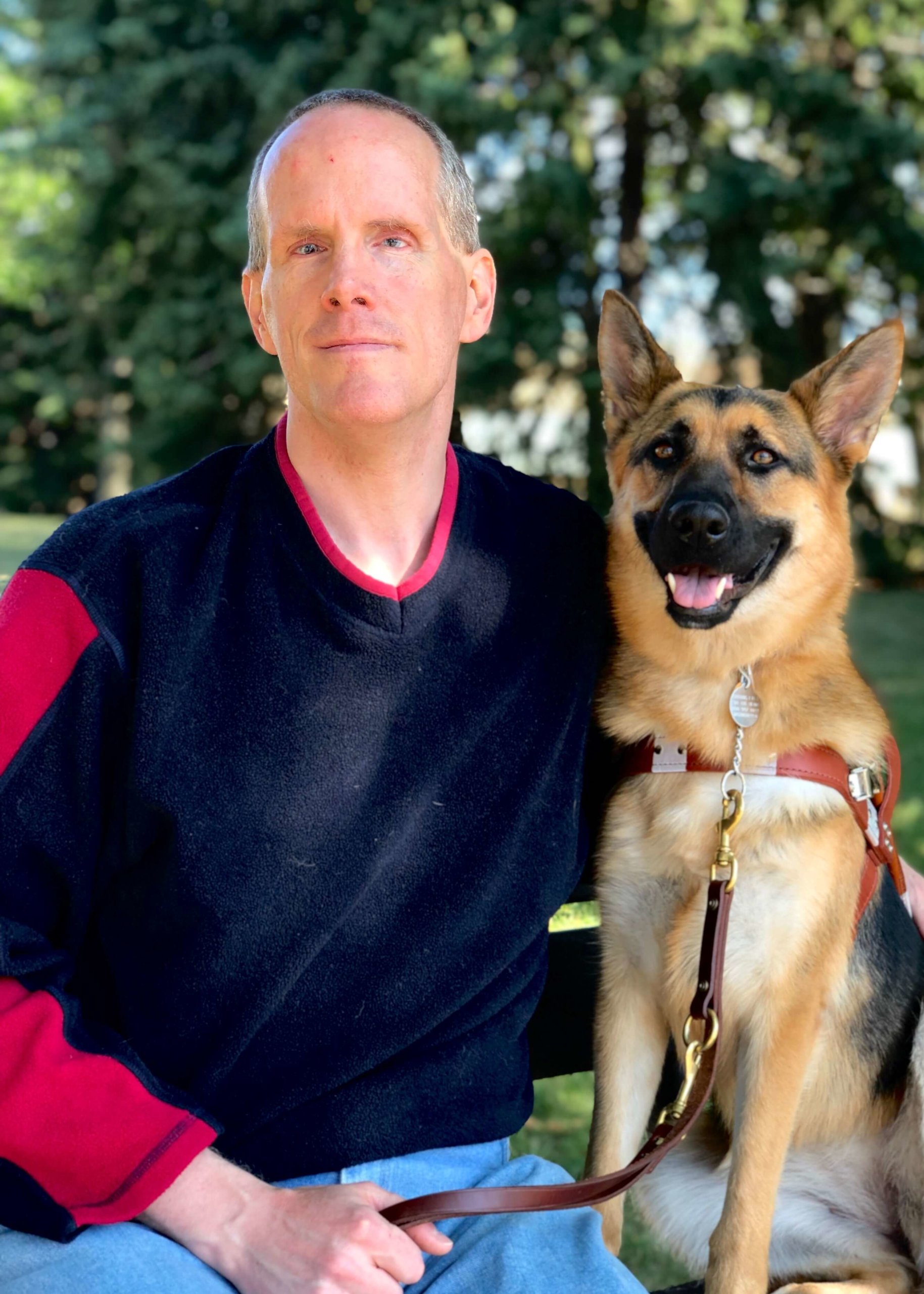 A formal photo of Kevin with black and tan German Shepherd Hedy.