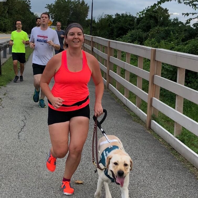 Graduate Allison Camire and guide dog Kennedy run together
