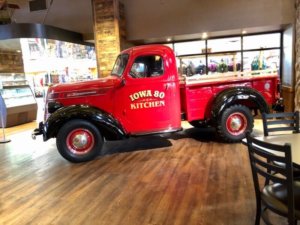 An old-fashioned red pick-up truck display is parked inside the massive Iowa I-80 truckstop.