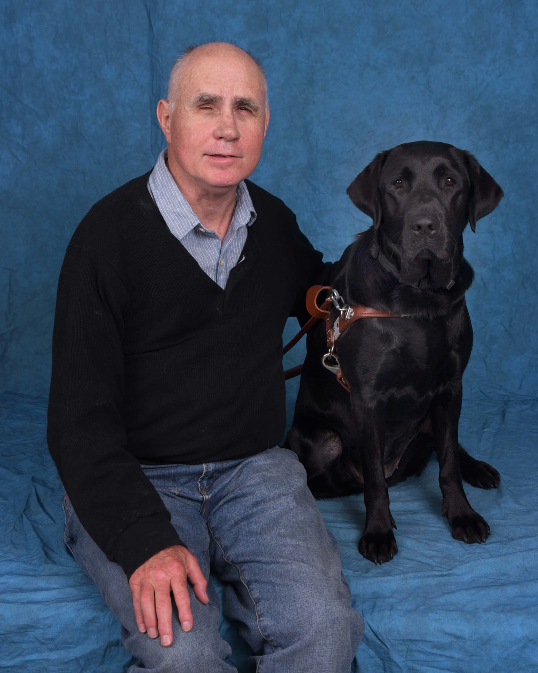 Formal photo of Jim and black lab guide dog Vespa