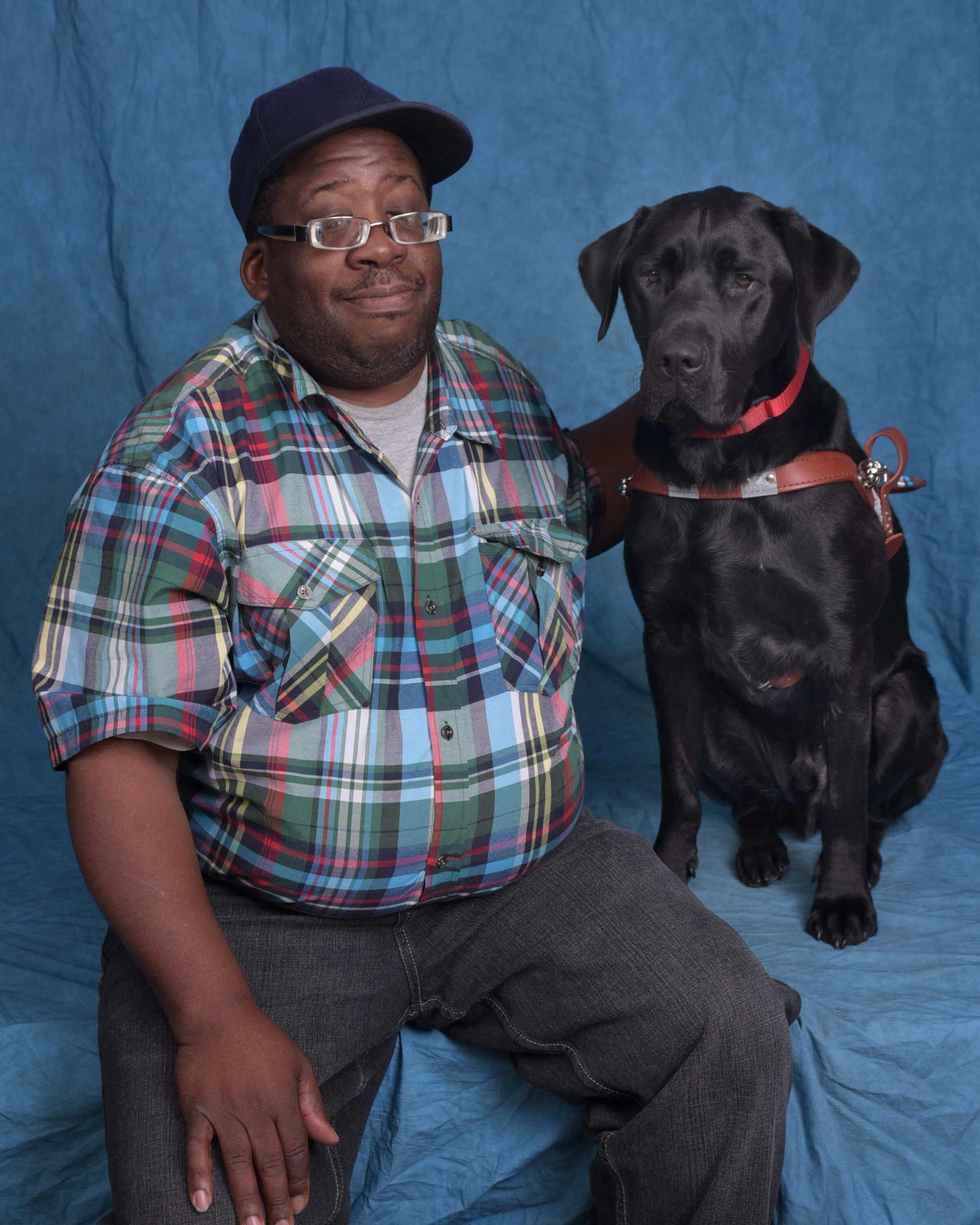 James and Vern, a black lab guide dog in harness.