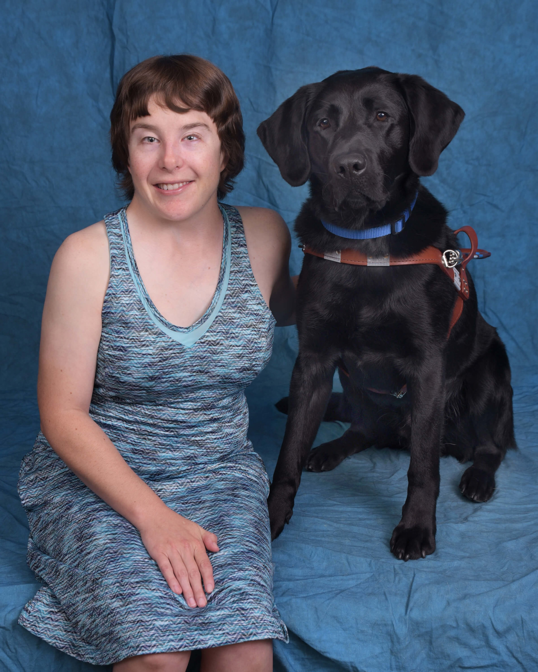 Kimberly and Sparrow, a black lab guide dog in harness.