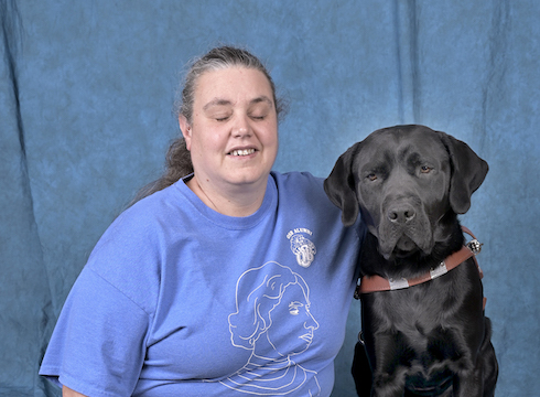 Graduate Kristi and black Lab guide Derek