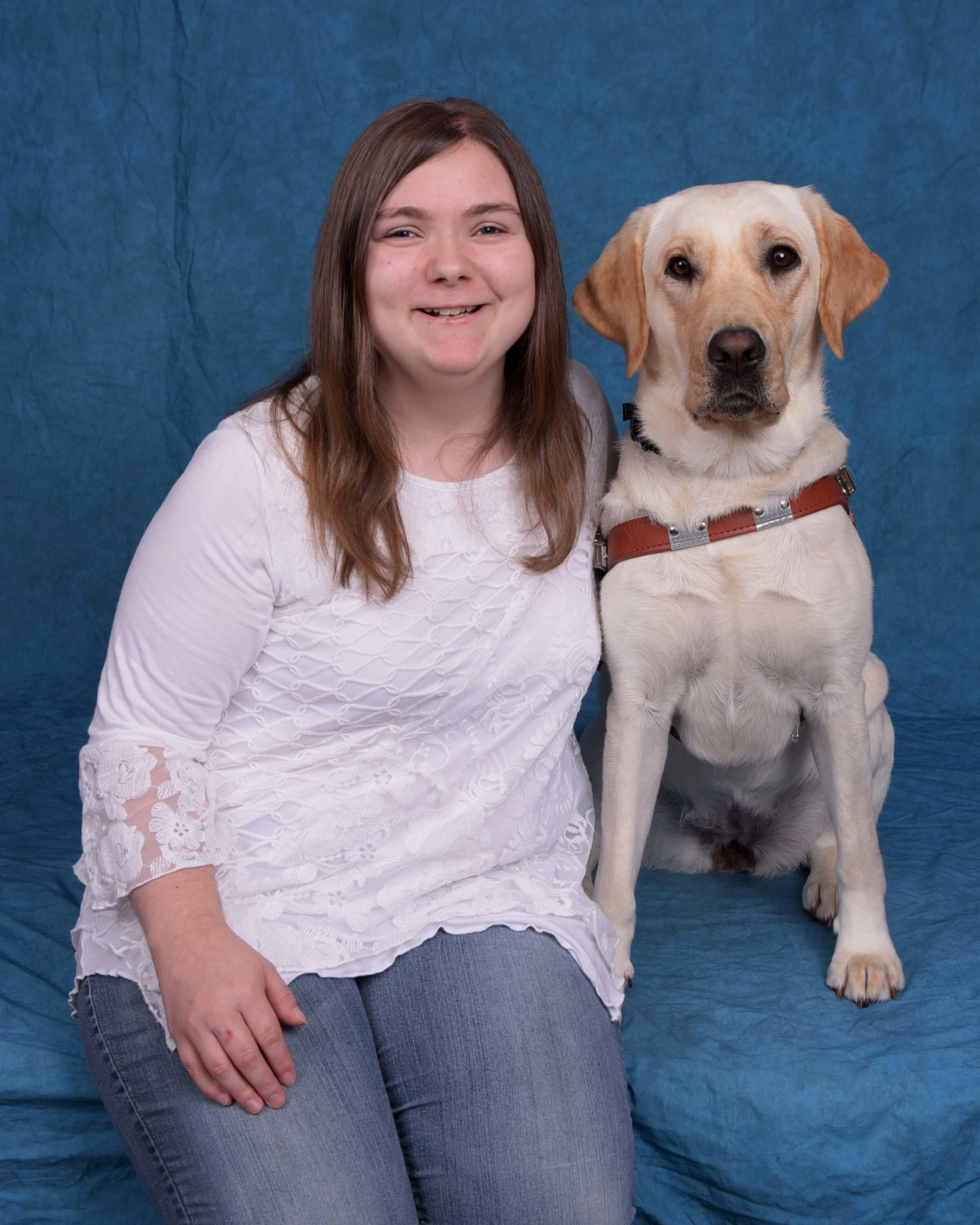A formal photo of Elle with yellow lab guide dog Fauna.
