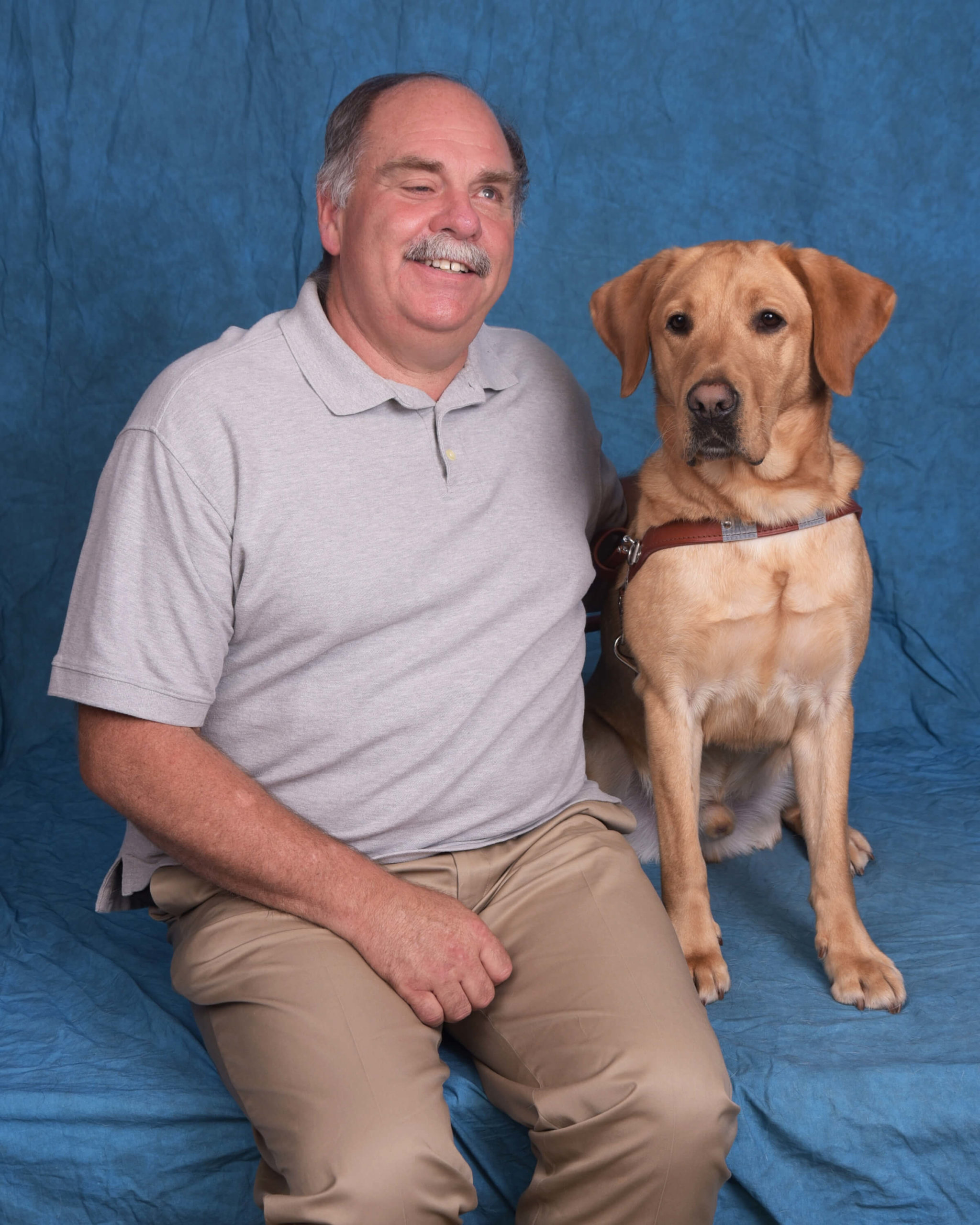 Marvin and Jude, a yellow lab guide dog in harness.