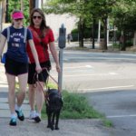 June graduate Maryann and guide dog Lopey walk down a sidewalk during a training session