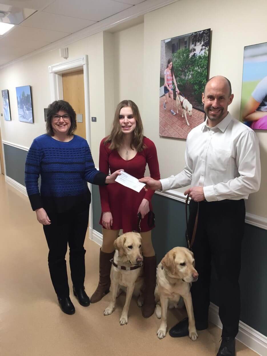 Kristine Carney and graduate Melissa Carney present Thomas Panek with a donation