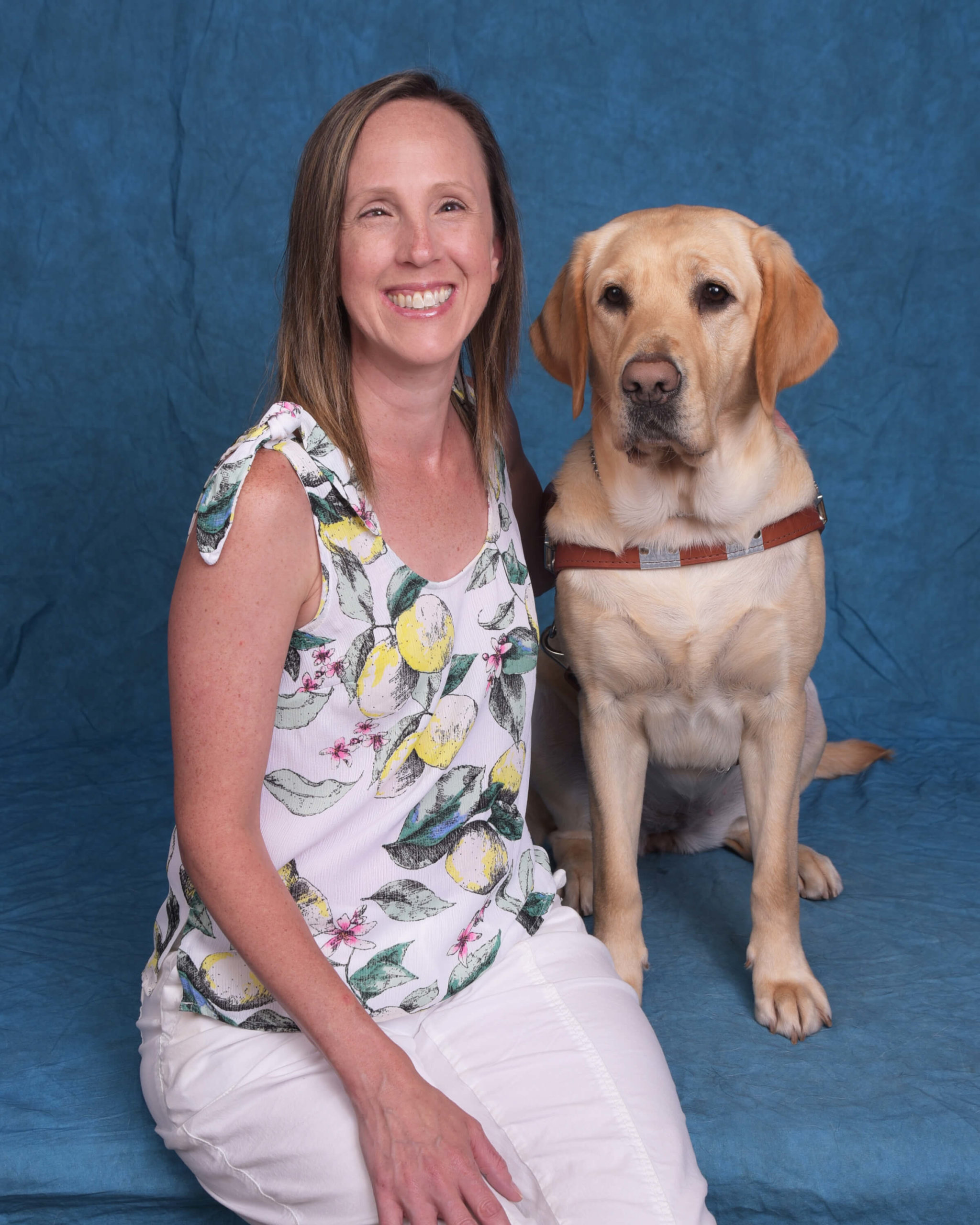 Pam and Blossom, a yellow lab guide dog in harness.
