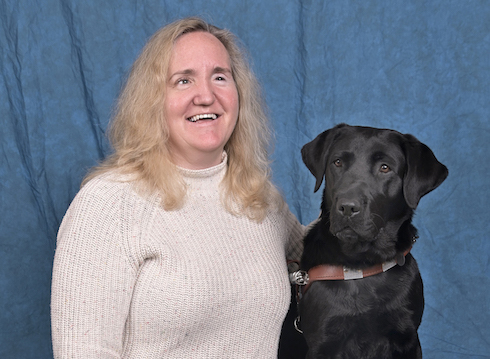 Graduate Stephanie and black Lab guide Cider