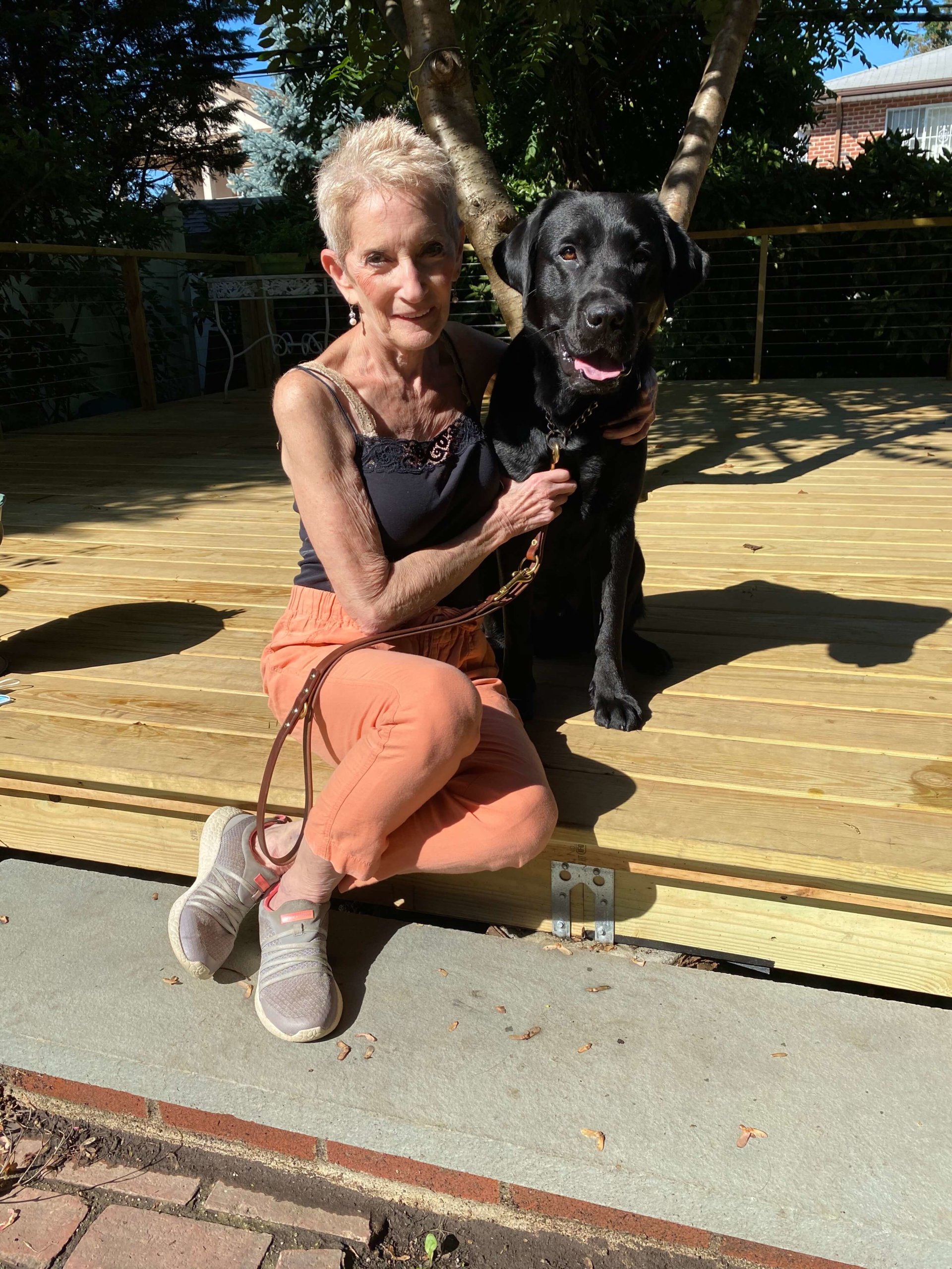 Susan and Oakley pose on wooden decking
