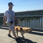 June graduate Tanner & guide dog Wes walk across a bridge pathway during a training session