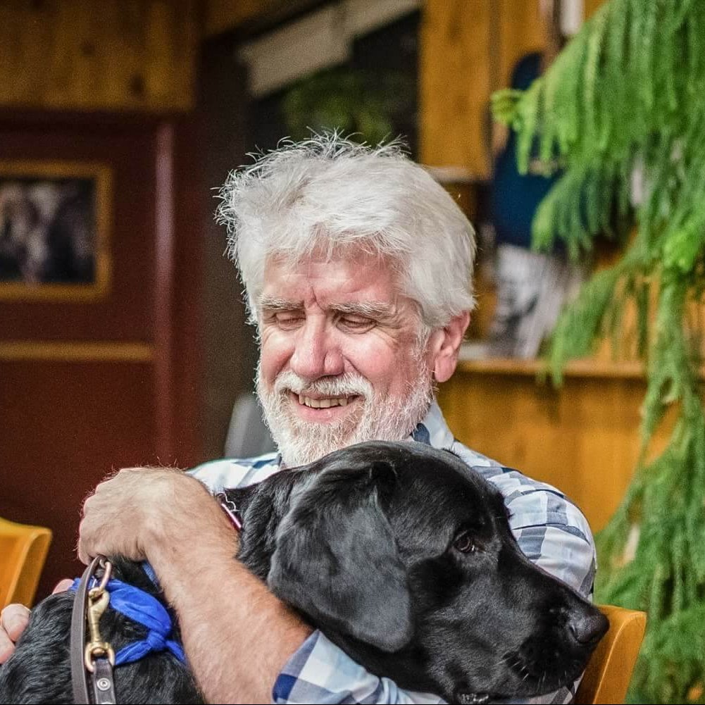 2016 graduate Terry McCann hugs his guide dog Mac