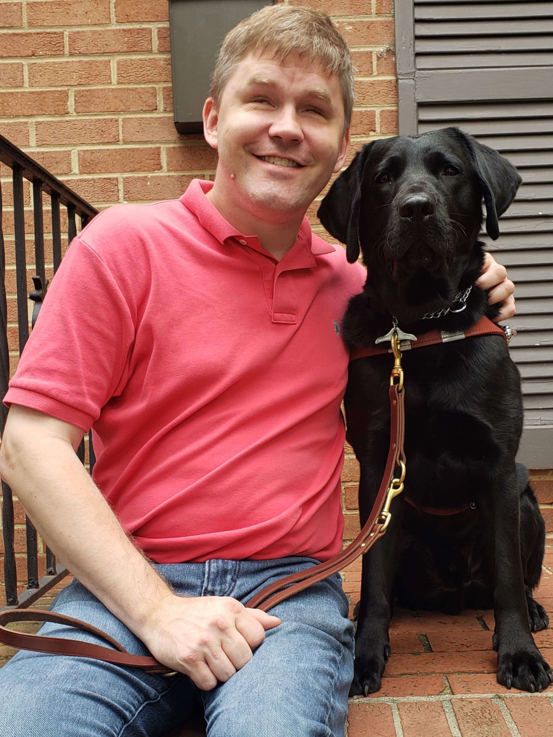 Eric poses with black lab guide dog Trent.