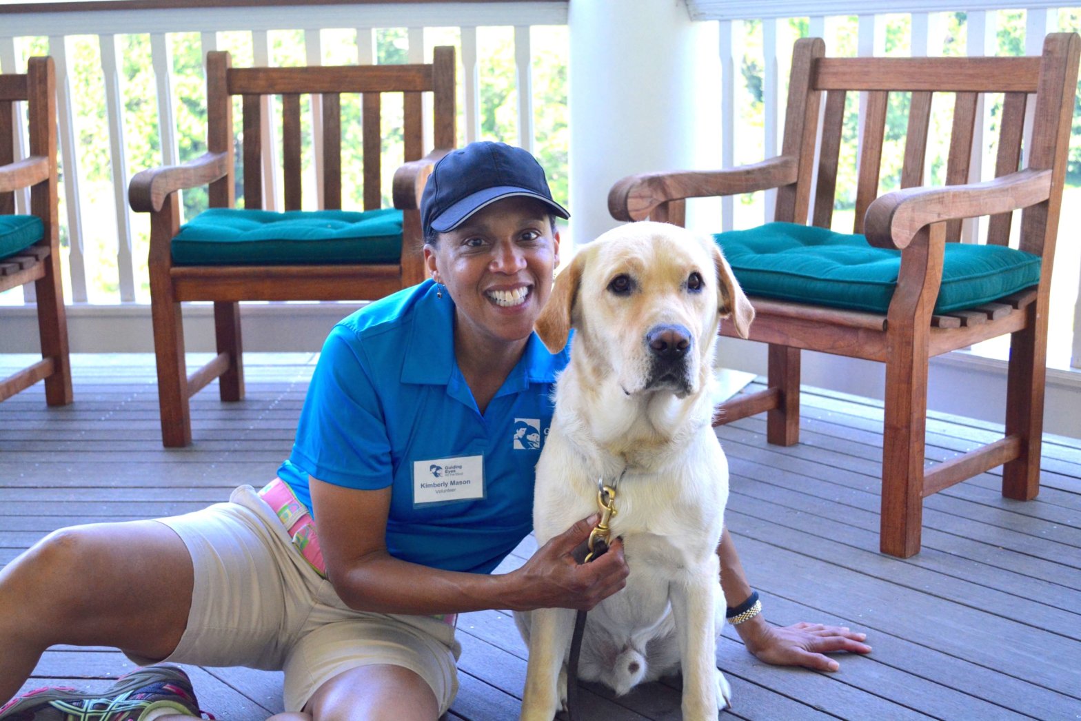 Volunteer Kimberly Mason poses next to a Guiding Eyes guide dog during an event