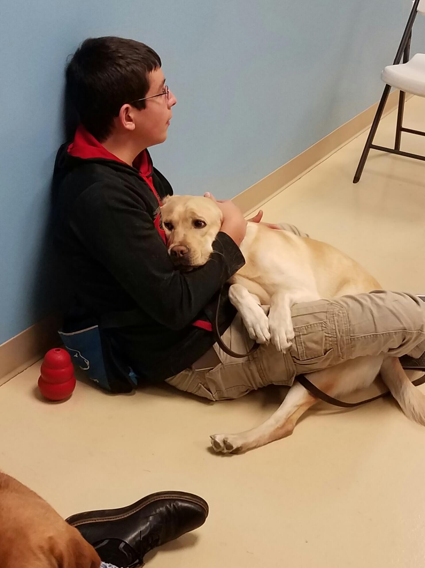 Zach sits with Hyde in puppy class