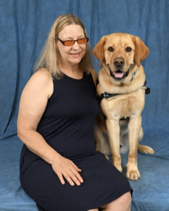 Graduate Lenore with yellow Lab guide Hachi