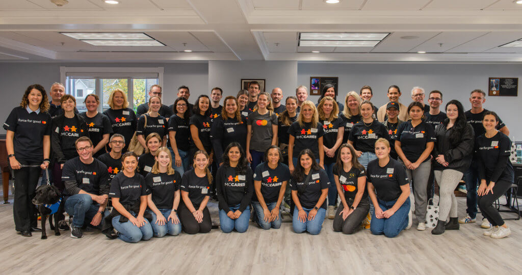 Mastercard employees pose for group photo with Rebekah Cross at Yorktown campus