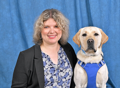 graduate portrait of Catherine with yellow Lab guide dog Griffin