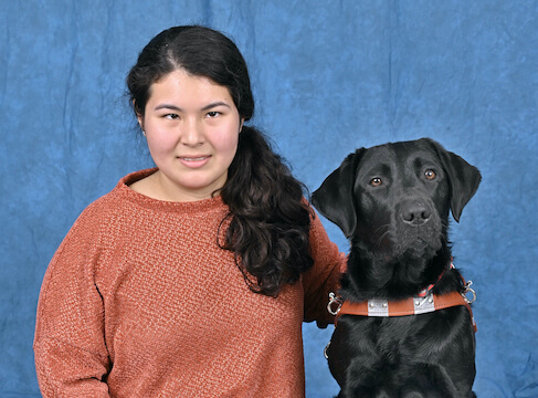 Grad Justine and black Lab guide dog Iris