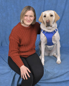 Abby and yellow Lab guide dog Igloo sit for their graduate portrait