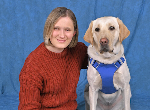 Abby and yellow Lab guide dog Igloo sit for their graduate portrait