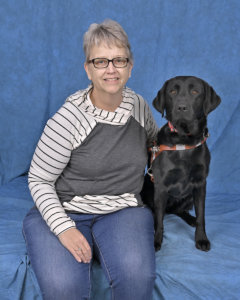 Jaqueline and black Lab guide dog Kathryn  sit for their team portrait