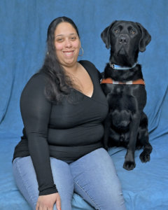 Elizabeth and black lab guide Yonkers sit in team portrait