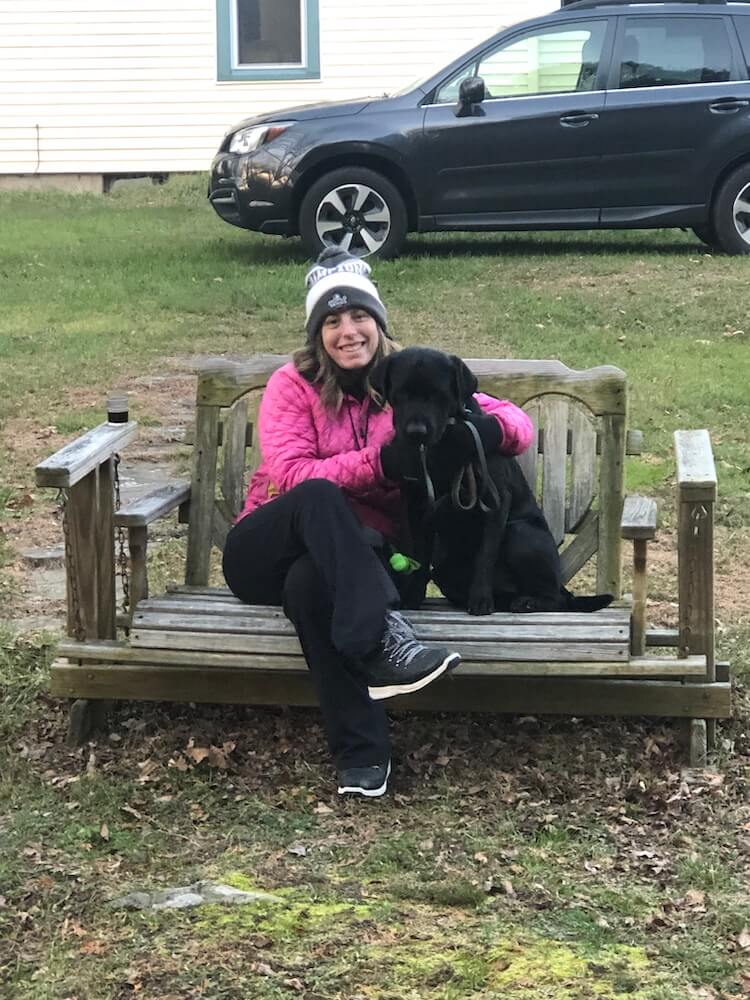Pup on program Jason sits on wood bench with raiser