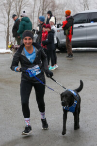 Payden, Running Guide Specialist with a black lab guide dog in unifly harness