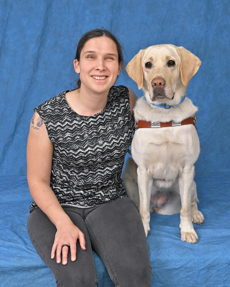 Daryl and yellow Lab guide dog Yasha pose for team portrait