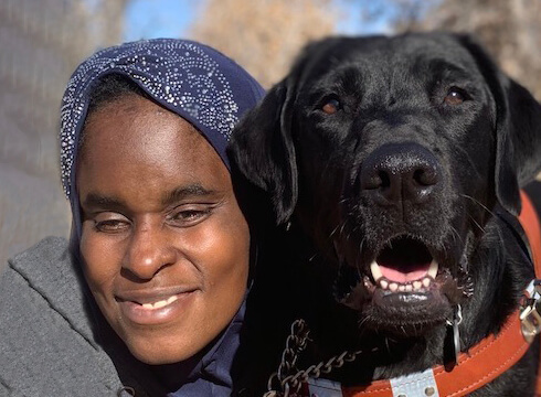 Kalia and black lab guide Roswell happily sit head to head