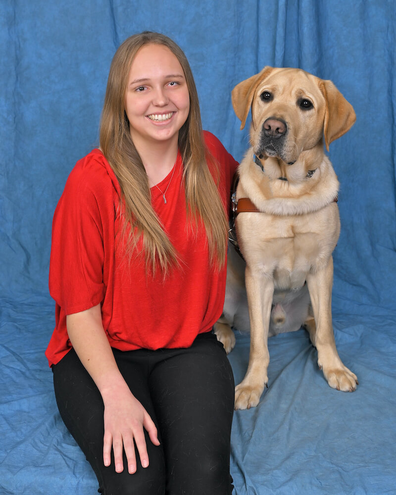 Macy and yellow Lab guide dog Kurt pose for team portrait