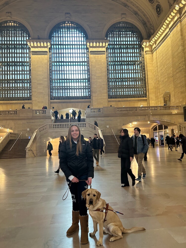Kurt sits next to Macy calmly in the middle of Grand Central Station during a training outing