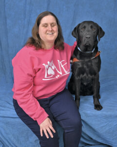 Abigail and black Lab Oakley sit for team portrait