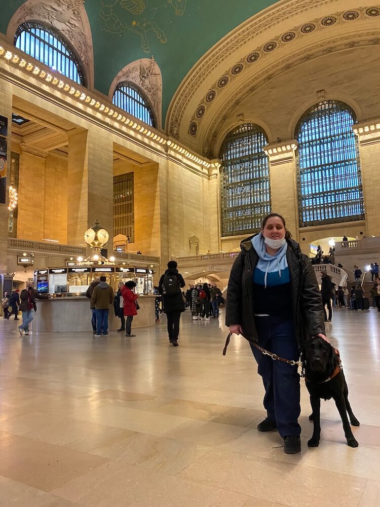 Abigail and black Lab Oakley pause in Grand Central Station, during NYC training