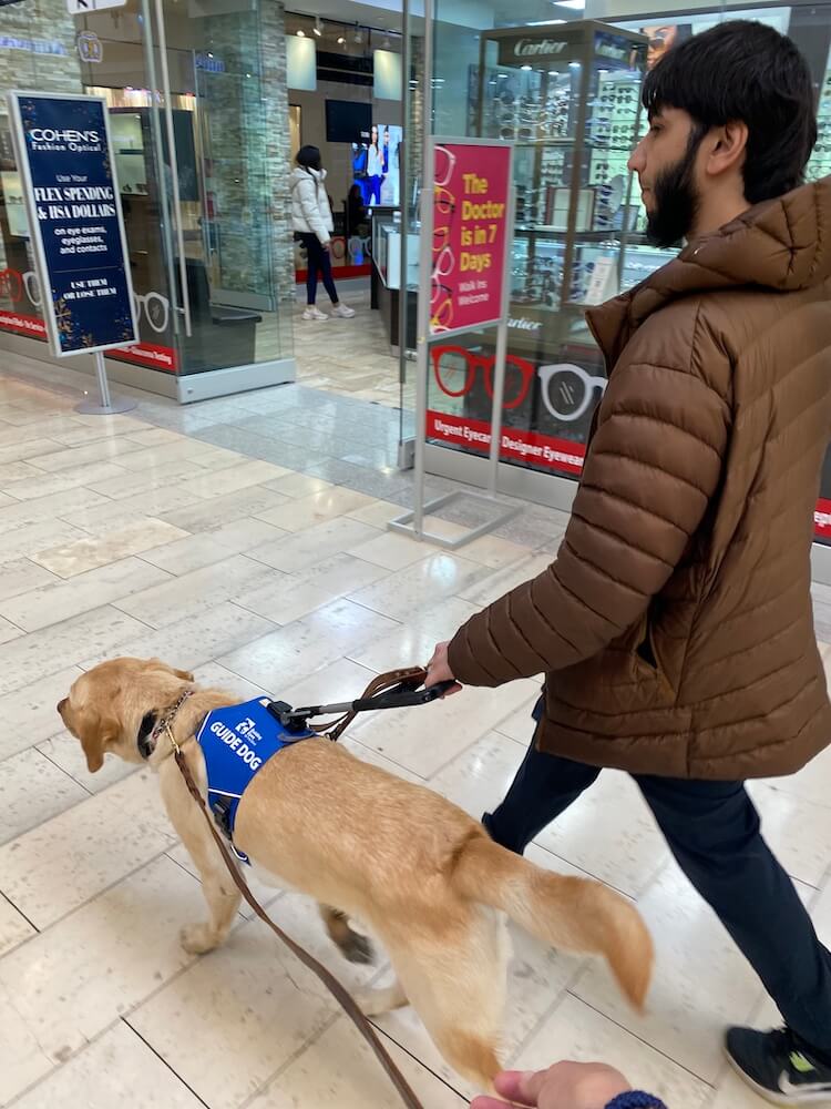 Ibraheem and guide Jake walk quickly through the mall